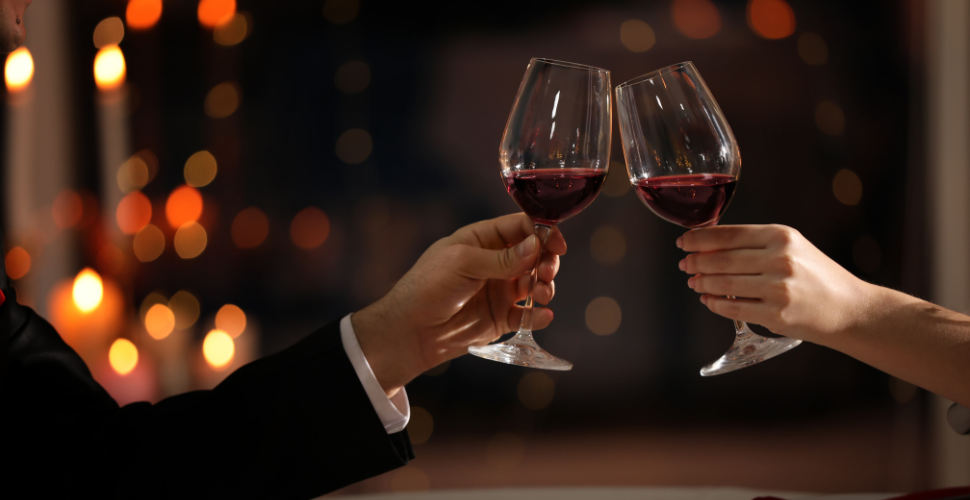 A photograph of two people clinking glasses filled with wine